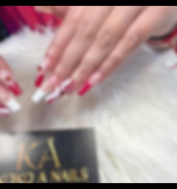 Imagen desenfocada de manos con uñas rojas sobre la tarjeta de Koko A Nails